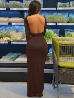 Woman in a long brown dress with an open back, viewed from behind