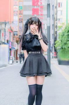 Woman in gothic fashion with pigtails and thigh-high socks on a street