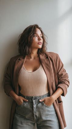 Woman with short brown hair wearing a jacket and jeans, looking away