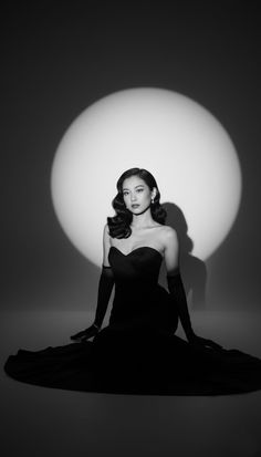 Woman in a strapless dress and long gloves sitting in a spotlight