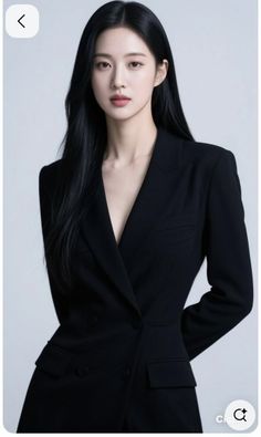 Woman with long black hair wearing a black blazer in a studio setting