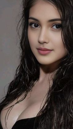 Woman with wet, dark hair and visible cleavage in a close-up portrait
