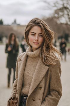 Woman with long brown hair wearing a turtleneck sweater and winter coat outdoors