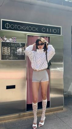 Woman in a polka dot top and shorts posing in front of a photo booth