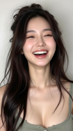 Woman with long dark hair smiling, showing cleavage