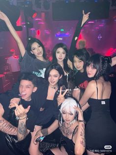Group of people posing in a nightclub with neon lighting