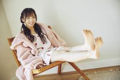Woman in pajamas and a pink robe sitting in a chair with her feet up