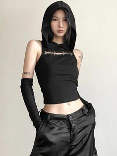 Woman in a black hooded crop top and long gloves with exposed midriff