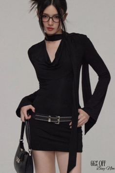 Woman in a black dress with a choker and glasses posing in a studio