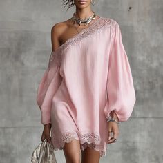 Woman in a pink off-shoulder dress with lace trim and silver jewelry