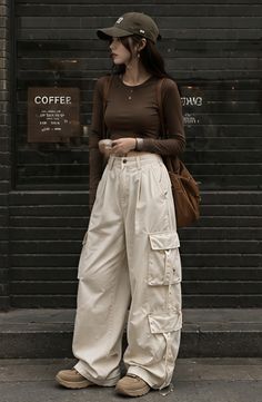 Woman in cargo pants and a long sleeve shirt standing outdoors