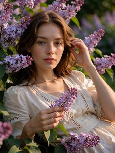 Woman with long hair and freckles among lilac flowers