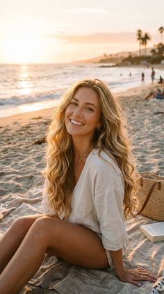 Woman with long blonde hair smiling on a beach at golden hour