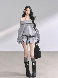 Woman with long black hair wearing an off-shoulder top and black boots