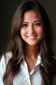 Woman with long brown hair wearing a white shirt, smiling at the camera