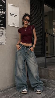 Woman in a crop top and baggy jeans posing outdoors