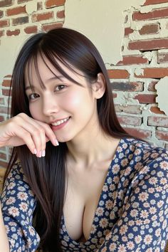 Woman with long dark hair smiling in a floral dress with cleavage visible