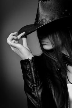 Woman in a cowboy hat and leather jacket in a black and white portrait