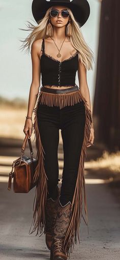 Woman in a cowboy hat and fringe pants walking outdoors