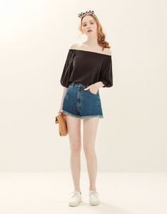 Woman in an off-shoulder top and denim shorts with a gingham headband