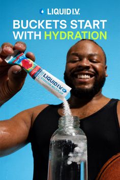 Man in a black tank top pouring hydration powder into a bottle