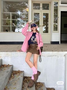 Woman in a pink shirt and brown skirt with a baseball cap and headphones outdoors