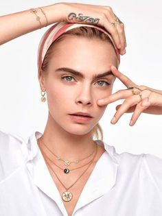 Woman wearing a headband, white shirt, and multiple pieces of jewelry
