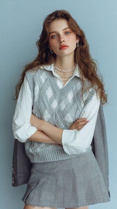 Woman with long wavy hair wearing an argyle vest and pleated skirt