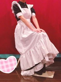 Person in a maid outfit with a white apron against a red background
