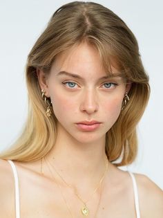 Young woman with blonde hair and blue eyes wearing gold jewelry