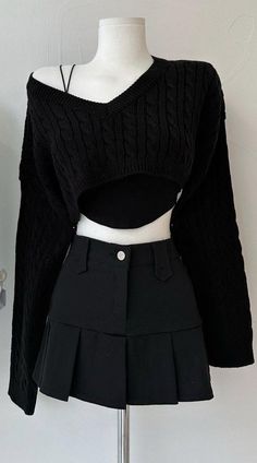 Black cropped sweater and pleated skirt on a white mannequin