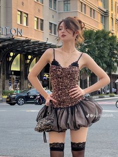 Woman in a leopard print dress and thigh high stockings on a city street