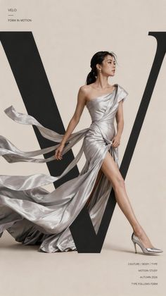 Woman in a flowing silver dress with a high slit and one shoulder design
