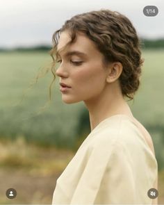 Woman with curly hair and bare shoulder in an outdoor setting