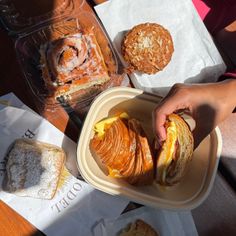 Assortment of bakery items including a cinnamon roll, muffin, and croissant sandwich