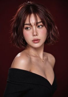 Woman with short hair and freckles wearing an off-shoulder top and gold necklace