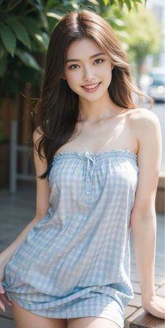 Woman with long hair wearing a strapless plaid top outdoors