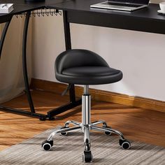Black swivel office chair with a black desk on a wooden floor