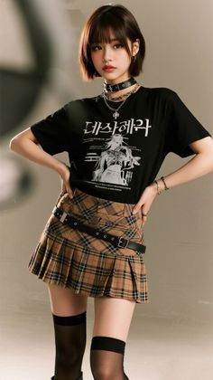Woman with short hair wearing a plaid skirt and black t-shirt in a studio