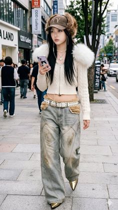 Woman in a furry hat and cropped cardigan with wide leg jeans on a city street