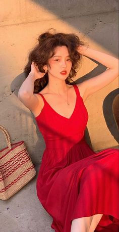 Woman in a red dress with curly hair in golden hour lighting
