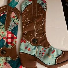 Two decorative cowboy boots with quilted floral and patchwork designs