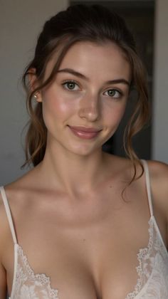 Woman with green eyes and brown hair wearing a white lace-trimmed top