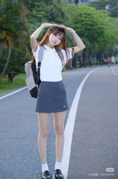 Young woman in a school uniform with a backpack posing outdoors