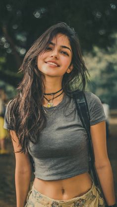 Smiling woman with long hair wearing a crop top and choker outdoors