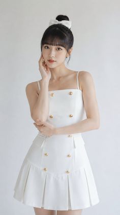 Woman in a white dress with gold buttons and a white bow in her hair