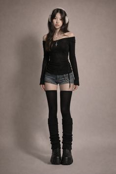Woman with long hair wearing an off-shoulder top, denim shorts, and platform boots