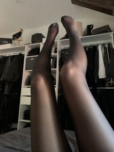 Person wearing black tights with legs raised in a bedroom setting