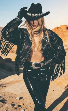 Woman in a cowboy hat and fringed leather jacket in a desert setting