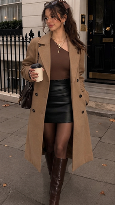 Woman in a long coat, leather skirt, and knee-high boots on a street